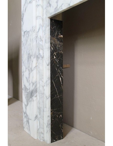 Antique iconic Art Deco mantelpiece carved in white veined Arabescato marble with Portoro marble inserts.