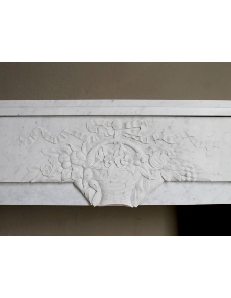 Antique genuine Art Deco mantelpiece, with iconic architecture and floral decorations, carved in white Carrara marble.