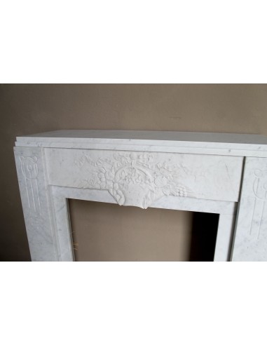 Antique genuine Art Deco mantelpiece, with iconic architecture and floral decorations, carved in white Carrara marble.