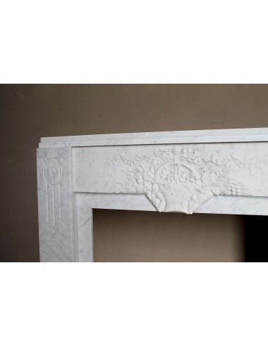 Antique genuine Art Deco mantelpiece, with iconic architecture and floral decorations, carved in white Carrara marble.