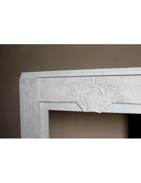 Antique genuine Art Deco mantelpiece, with iconic architecture and floral decorations, carved in white Carrara marble.