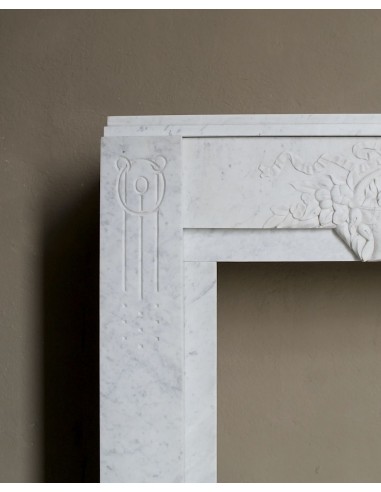 Antique genuine Art Deco mantelpiece, with iconic architecture and floral decorations, carved in white Carrara marble.