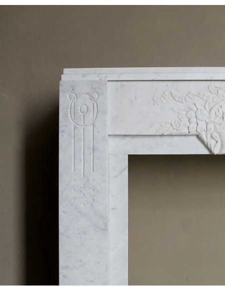 Antique genuine Art Deco mantelpiece, with iconic architecture and floral decorations, carved in white Carrara marble.