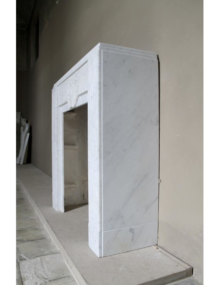 Antique genuine Art Deco mantelpiece, with iconic architecture and floral decorations, carved in white Carrara marble.