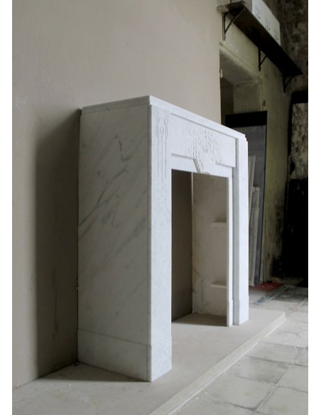 Antique genuine Art Deco mantelpiece, with iconic architecture and floral decorations, carved in white Carrara marble.