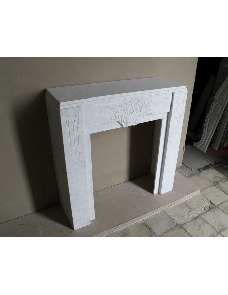 Antique genuine Art Deco mantelpiece, with iconic architecture and floral decorations, carved in white Carrara marble.