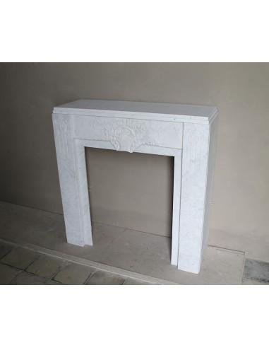 Antique genuine Art Deco mantelpiece, with iconic architecture and floral decorations, carved in white Carrara marble.
