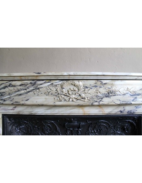 Neoclassical mantelpiece in veined Statuary marble with tones from white to beige to violet, with its original cast iron insert.