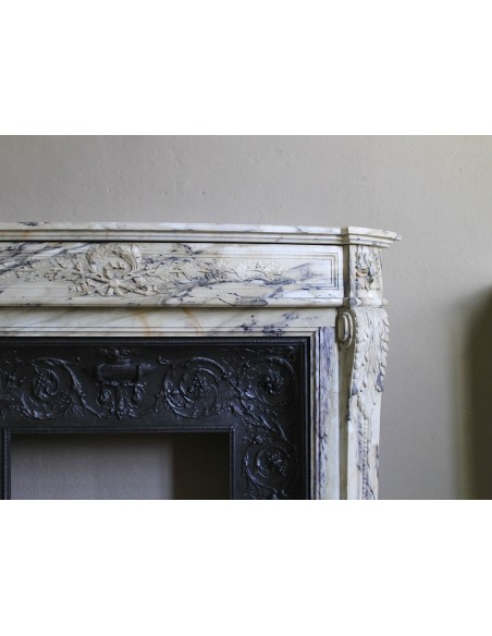Neoclassical mantelpiece in veined Statuary marble with tones from white to beige to violet, with its original cast iron insert.