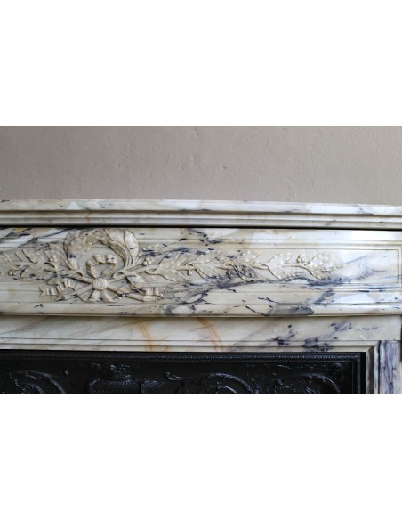 Neoclassical mantelpiece in veined Statuary marble with tones from white to beige to violet, with its original cast iron insert.