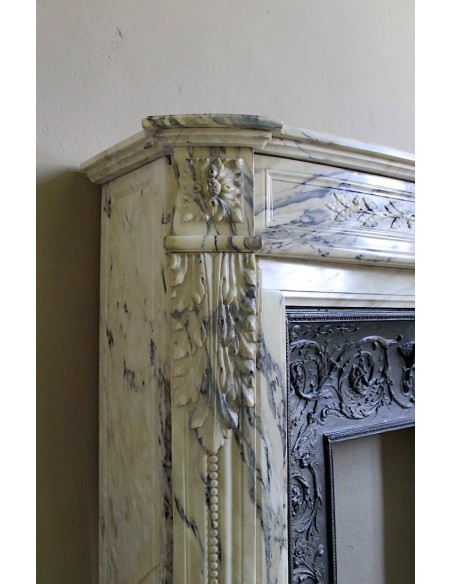 Neoclassical mantelpiece in veined Statuary marble with tones from white to beige to violet, with its original cast iron insert.