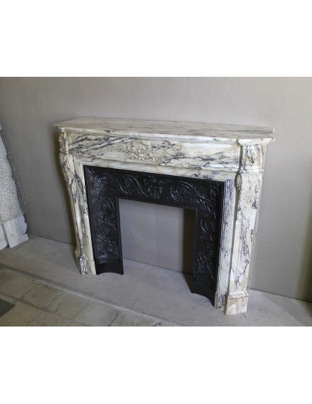 Neoclassical mantelpiece in veined Statuary marble with tones from white to beige to violet, with its original cast iron insert.