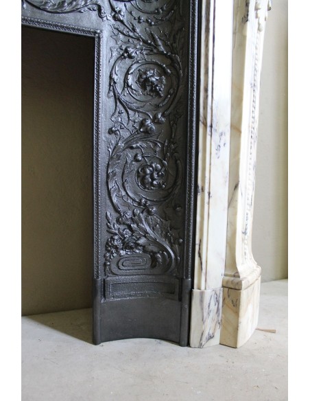 Neoclassical mantelpiece in veined Statuary marble with tones from white to beige to violet, with its original cast iron insert.