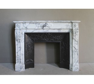 Neoclassical “Trois Fleurs” fireplace mantel in white veined marble, provided with its original cast iron insert.