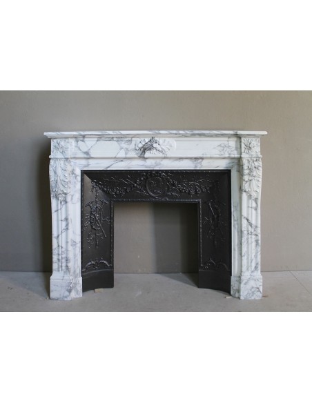 Neoclassical “Trois Fleurs” fireplace mantel in white veined marble, provided with its original cast iron insert.