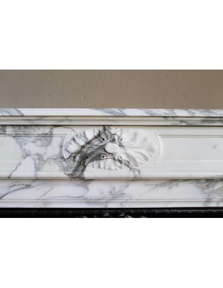 Neoclassical “Trois Fleurs” fireplace mantel in white veined marble, provided with its original cast iron insert.