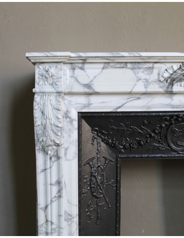 Neoclassical “Trois Fleurs” fireplace mantel in white veined marble, provided with its original cast iron insert.