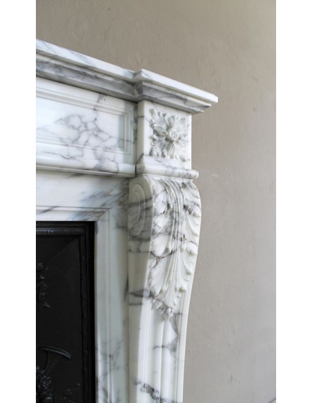 Neoclassical “Trois Fleurs” fireplace mantel in white veined marble, provided with its original cast iron insert.