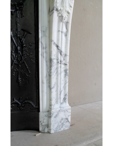 Neoclassical “Trois Fleurs” fireplace mantel in white veined marble, provided with its original cast iron insert.