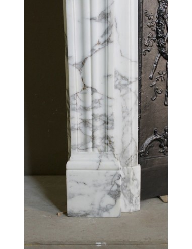 Neoclassical “Trois Fleurs” fireplace mantel in white veined marble, provided with its original cast iron insert.