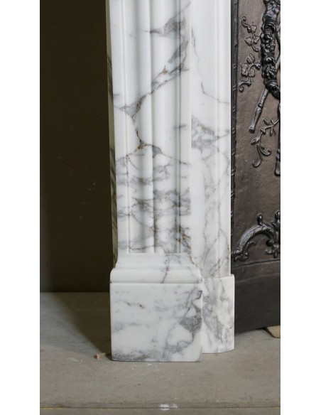 Neoclassical “Trois Fleurs” fireplace mantel in white veined marble, provided with its original cast iron insert.