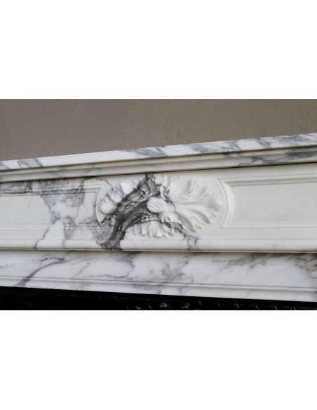Neoclassical “Trois Fleurs” fireplace mantel in white veined marble, provided with its original cast iron insert.
