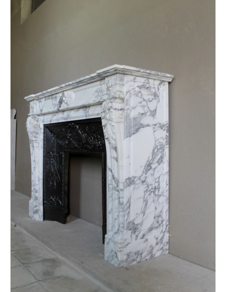 Neoclassical “Trois Fleurs” fireplace mantel in white veined marble, provided with its original cast iron insert.