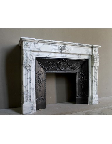 Neoclassical “Trois Fleurs” fireplace mantel in white veined marble, provided with its original cast iron insert.