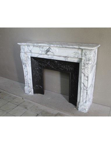 Neoclassical “Trois Fleurs” fireplace mantel in white veined marble, provided with its original cast iron insert.