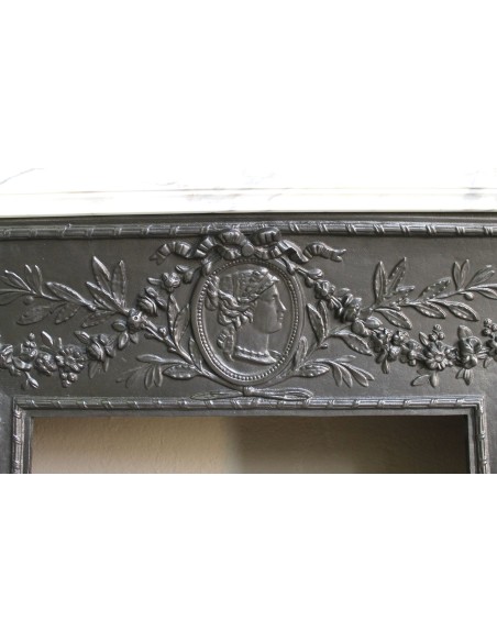 Neoclassical “Trois Fleurs” fireplace mantel in white veined marble, provided with its original cast iron insert.