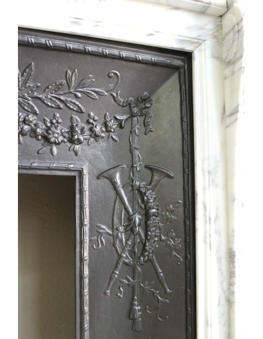 Neoclassical “Trois Fleurs” fireplace mantel in white veined marble, provided with its original cast iron insert.