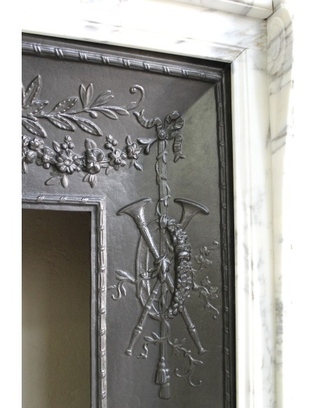 Neoclassical “Trois Fleurs” fireplace mantel in white veined marble, provided with its original cast iron insert.
