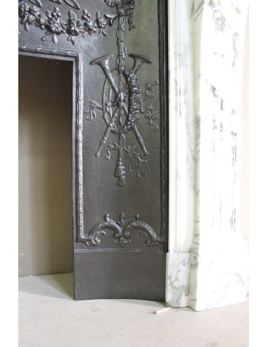 Neoclassical “Trois Fleurs” fireplace mantel in white veined marble, provided with its original cast iron insert.