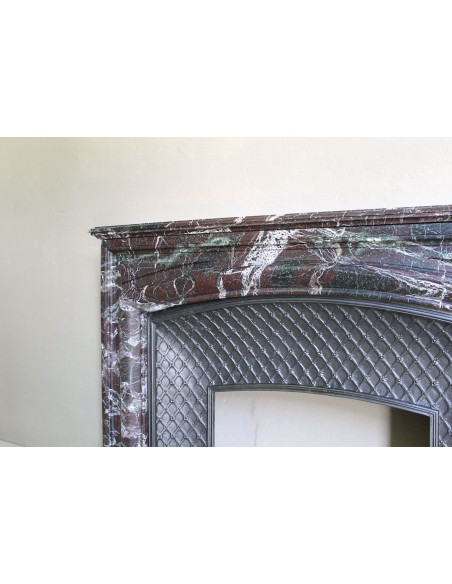 Antique “Boudin” mantelpiece in Levanto marble in red, green, violet, and white. This fireplace mantel has its cast iron insert.