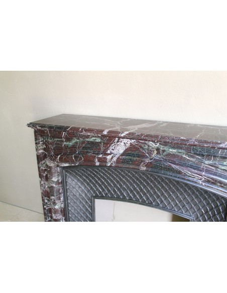 Antique “Boudin” mantelpiece in Levanto marble in red, green, violet, and white. This fireplace mantel has its cast iron insert.
