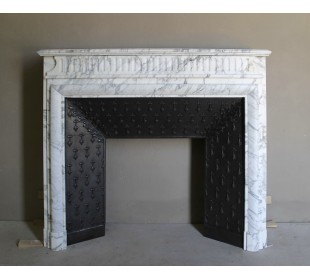 Antique “Boudin” fireplace mantel carved in veined white Calacatta marble. This mantel has its original cast iron insert.