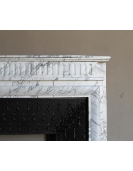 Antique “Boudin” fireplace mantel carved in veined white Calacatta marble. This mantel has its original cast iron insert.