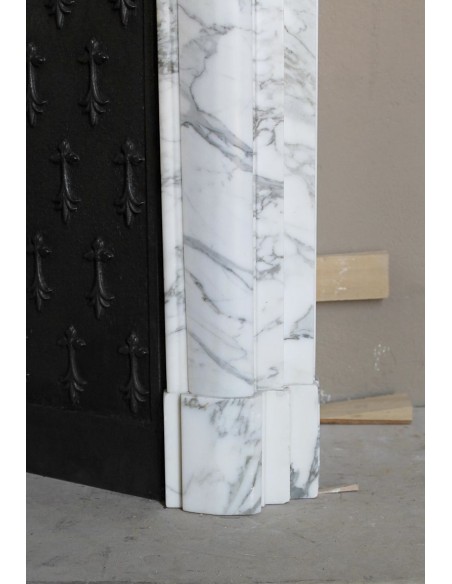 Antique “Boudin” fireplace mantel carved in veined white Calacatta marble. This mantel has its original cast iron insert.