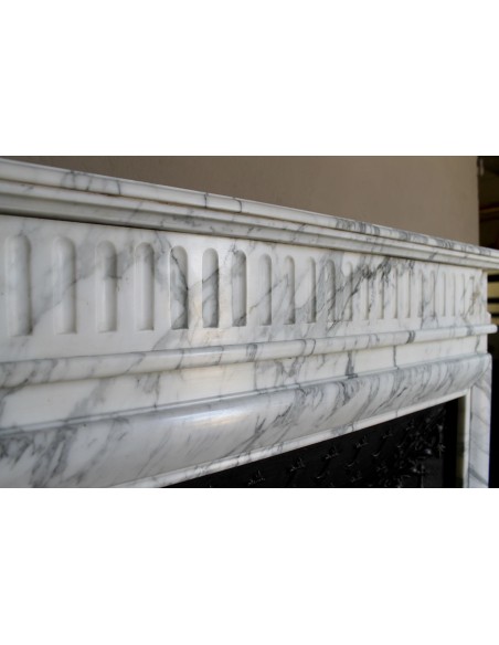 Antique “Boudin” fireplace mantel carved in veined white Calacatta marble. This mantel has its original cast iron insert.
