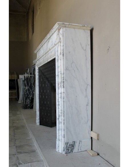 Antique “Boudin” fireplace mantel carved in veined white Calacatta marble. This mantel has its original cast iron insert.