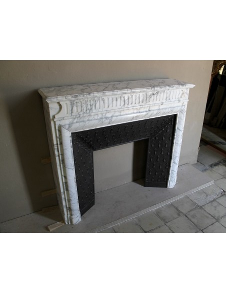 Antique “Boudin” fireplace mantel carved in veined white Calacatta marble. This mantel has its original cast iron insert.