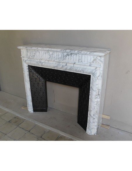 Antique “Boudin” fireplace mantel carved in veined white Calacatta marble. This mantel has its original cast iron insert.