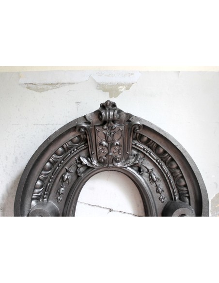 Antique Art Nouveau fireplace mantel in artistic cast iron. This antique mantelpiece is a genuine Parisian “Oeil de boeuf”.