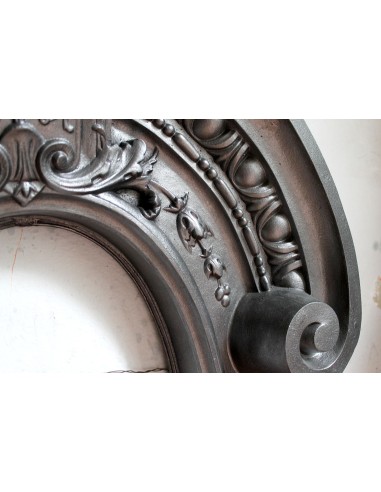 Antique Art Nouveau fireplace mantel in artistic cast iron. This antique mantelpiece is a genuine Parisian “Oeil de boeuf”.