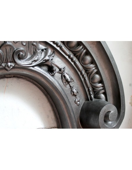 Antique Art Nouveau fireplace mantel in artistic cast iron. This antique mantelpiece is a genuine Parisian “Oeil de boeuf”.