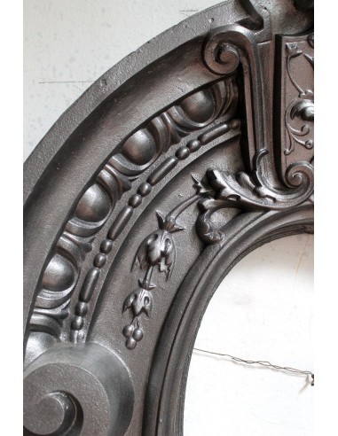 Antique Art Nouveau fireplace mantel in artistic cast iron. This antique mantelpiece is a genuine Parisian “Oeil de boeuf”.