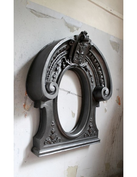 Antique Art Nouveau fireplace mantel in artistic cast iron. This antique mantelpiece is a genuine Parisian “Oeil de boeuf”.