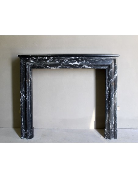 Antique “Bolection" mantelpiece in black marble with white veins. This is an elegant, contemporary and minimalist mantel.