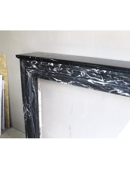 Antique “Bolection" mantelpiece in black marble with white veins. This is an elegant, contemporary and minimalist mantel.