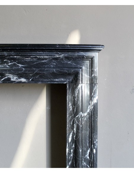 Antique “Bolection" mantelpiece in black marble with white veins. This is an elegant, contemporary and minimalist mantel.